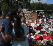 Foto de archivo que muestra a varias personas que visitan un monumento conmemorativo, el cual fue erigido en honor de las personas asesinadas en la Escuela Primaria Robb, en Uvalde, Texas.