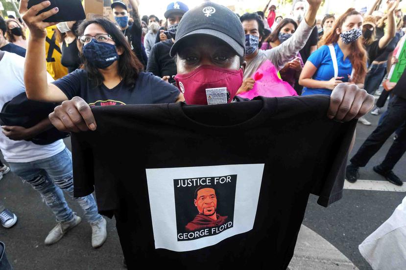Una manifestante muestra una camisa con el rostro de George Floyd durante una protesta en Los Angeles, California. (AP)