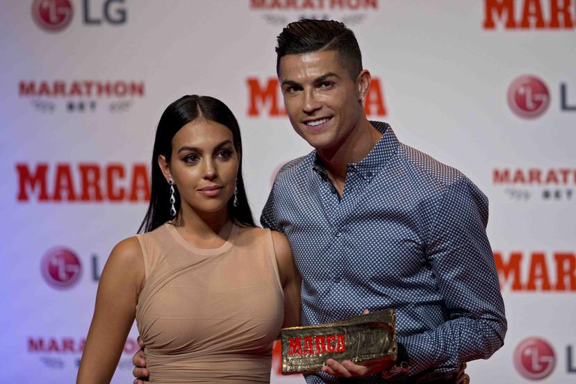 Cristiano Ronaldo posa junto con su compañera, Georgina Rodriguez, al recibir el premio MARCA Leyenda. (AP / Paul White)