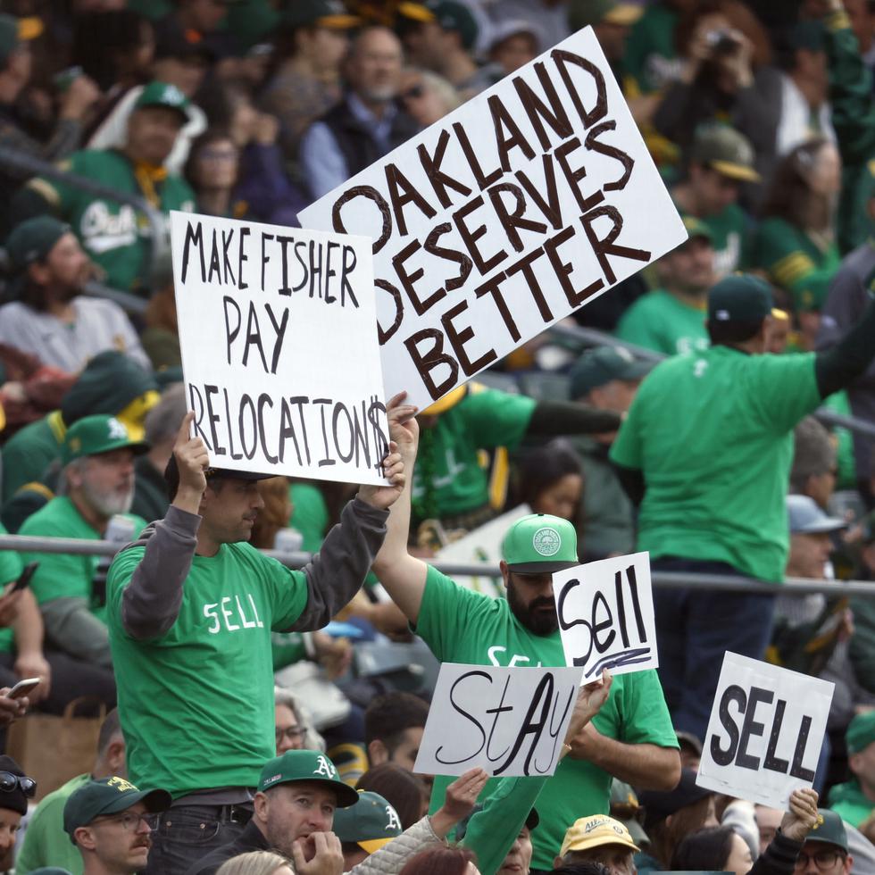 Fanáticos de los Athletics de Oakland muestran carteles pidiendo que el equipo no se mude a Las Vegas durante el juego del martes.