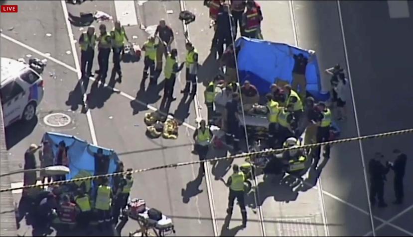 Personal de emergencia ayuda a víctimas atropelladas por un vehículo en Melbourne, Australia. (AP)