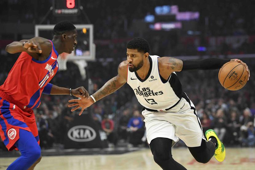 El jugador de los Clippers de Los Ángeles Paul George (derecha) intenta conducir la pelota ante su rival de los Pistons de Detroit. (AP)