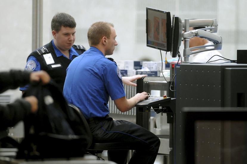 Agentes del TSA durante la inspección de maletas y otros artículos. (Archivo / EFE)
