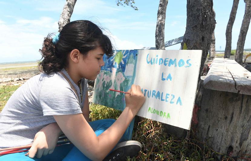 Alondra Caraballo Rodríguez disfruta de pintar rótulos en la Playa de Guayanilla, con mensajes de concienciación ambiental.