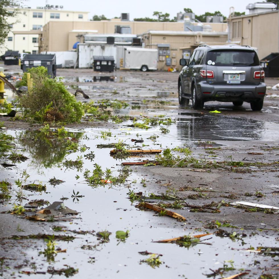 Escombros cubren una playa de estacionamiento en el centro comercial Causeway Plaza en Dunedin, Florida, jueves 12 de octubre de 2023. Una serie de tormentas en el norte de Florida dejaron una senda de autos, viviendas y tiendas destruidas. (Douglas R. Clifford/Tampa Bay Times via AP)