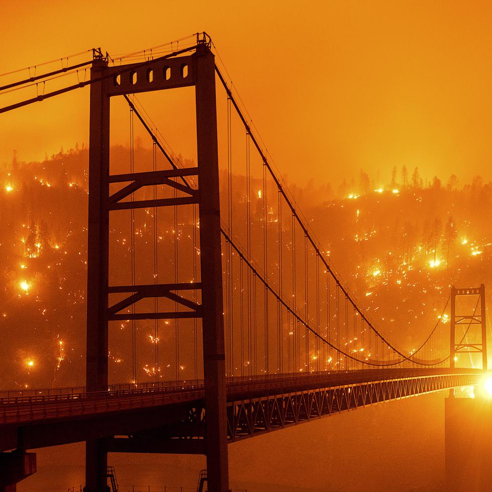En el año 2020, el estado de California experimentó el incendio forestal más extenso en su historia, identificado como "August Complex". En una foto tomada ese año, las llamas consumen parte del paisaje detrás del puente Bidwell Bar en Oroville, California.