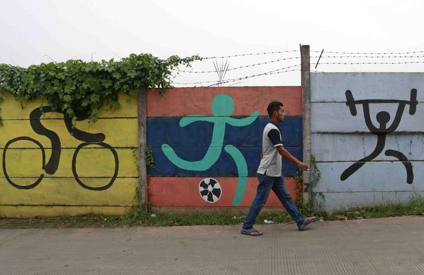 Un hombre pasa por delante de murales deportivos pintados originalmente en una pared como herramientas de promoción para los Juegos Asiáticos 2018 en Yakarta, Indonesia. (AP)
