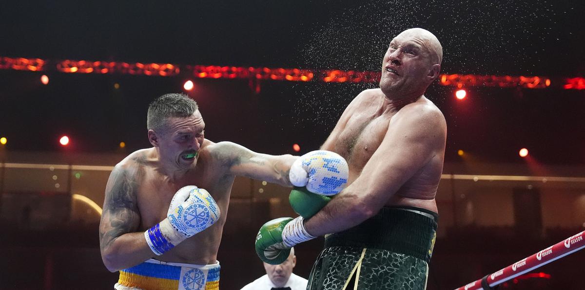 El británico Tyson Fury (derecha) recibe un golpe del ucraniano Oleksandr Usyk durante su pelea por el campeonato mundial indiscutible del peso pesado.
