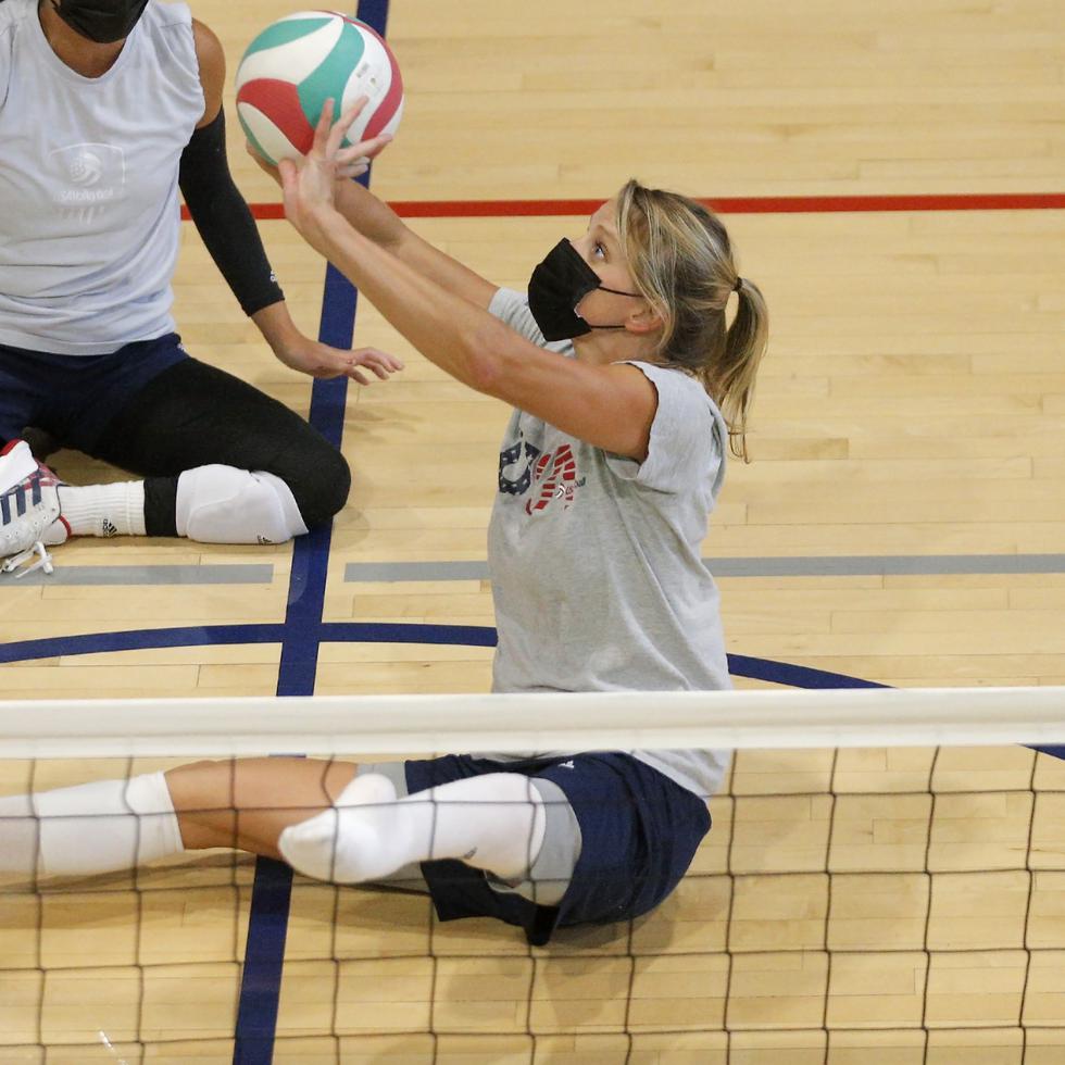 La estadounidense Lora Webster acomoda la pelota durante las prácticas del equipo de voleibol adaptado.