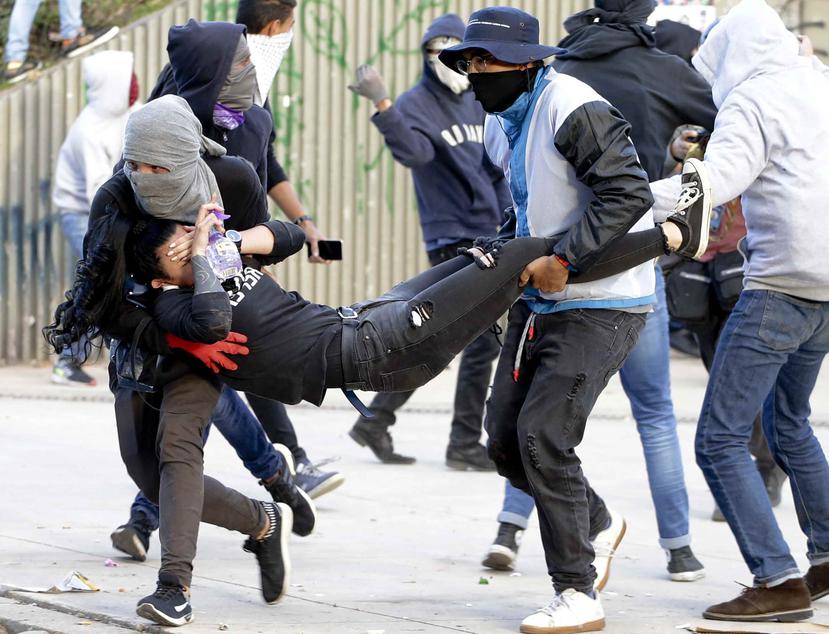 Estudiantes trasladan a un joven herido durante enfrentamientos con la policía en la Universidad Nacional de Bogotá, Colombia, el 26 de noviembre de 2019. (AP / Iván Valencia)