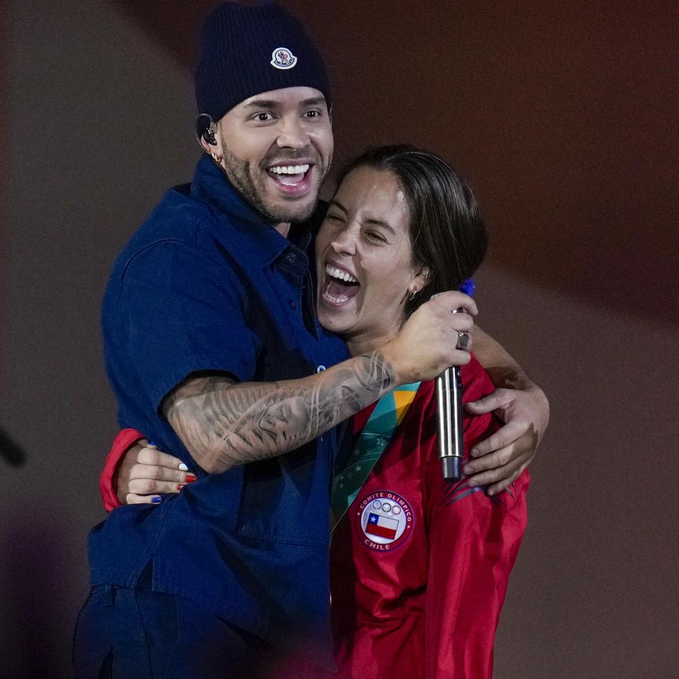 El cantante Prince Royce abraza una atleta chilena durante su presentación en tarima.