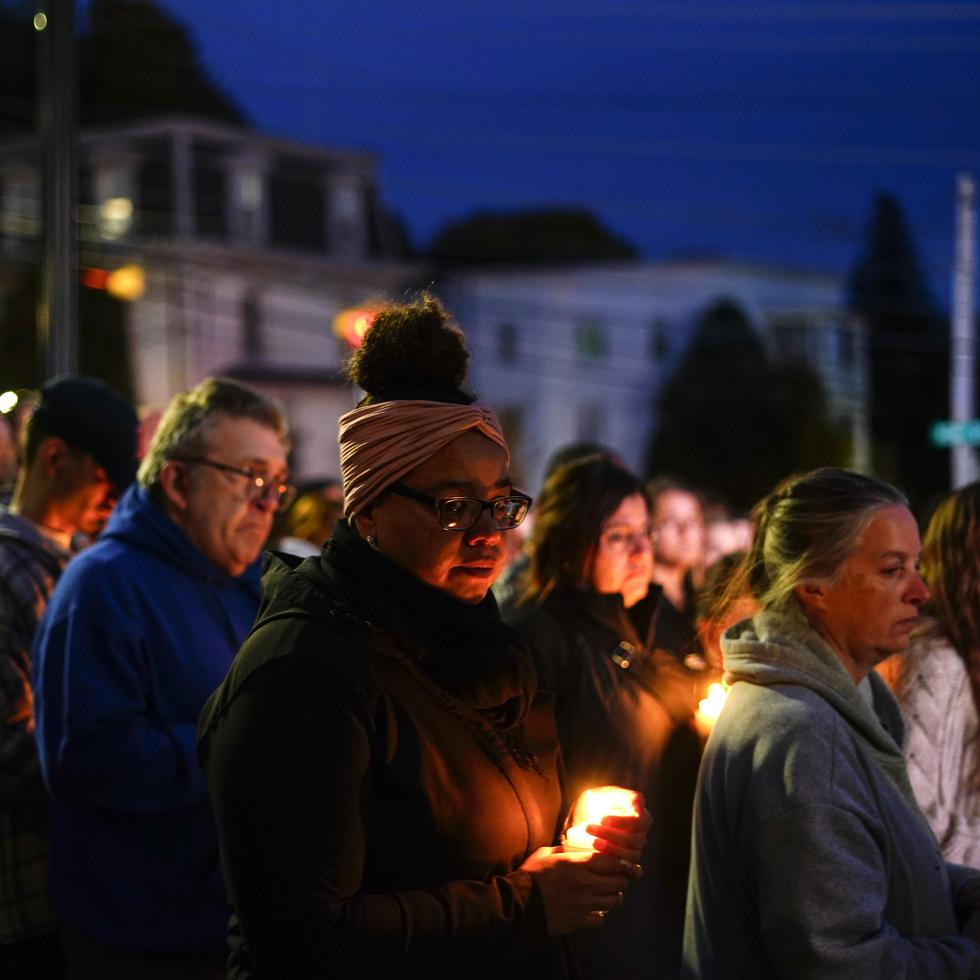 Un grupo de personas se congrega para una vigilia para las víctimas de un tiroteo masivo, el domingo 29 de octubre de 2023, afuera de la Basílica de San Pedro y San Pablo en Lewiston, Maine.
