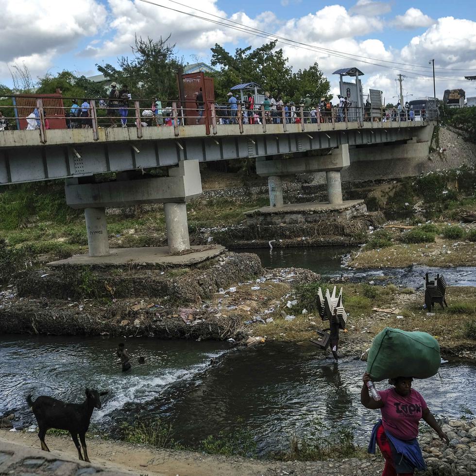 ARCHIVO - Gente se baña en el río Massacre en la frontera entre República Dominicana y Haití en Ouanaminthe, Haití 19 de noviembre de 2021. Las autoridades dominicanas han expulsado a 1.800 niños haitianos de regreso a su país, dijo UNICEF el 22 de noviembre de 2022. (AP Foto/Matias Delacroix, File)
