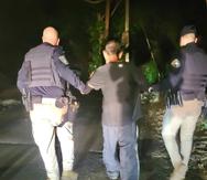 Agentes llevan al hombre arrestado este jueves en Vega Baja.