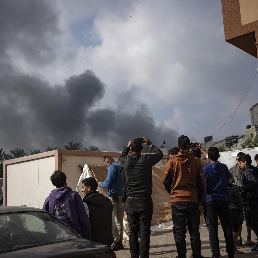 Palestinos observan el humo tras un ataque aéreo israelí en Jan Yunis, en la Franja de Gaza.