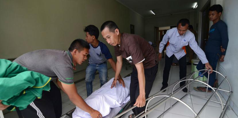 En esta imagen, tomada el 9 de abril de 2018, una familia traslada el cuerpo de un fallecido por consumir alcohol ilegal, en un hospital de Cicalengka, Java Occidental, Indonesia. (AP).