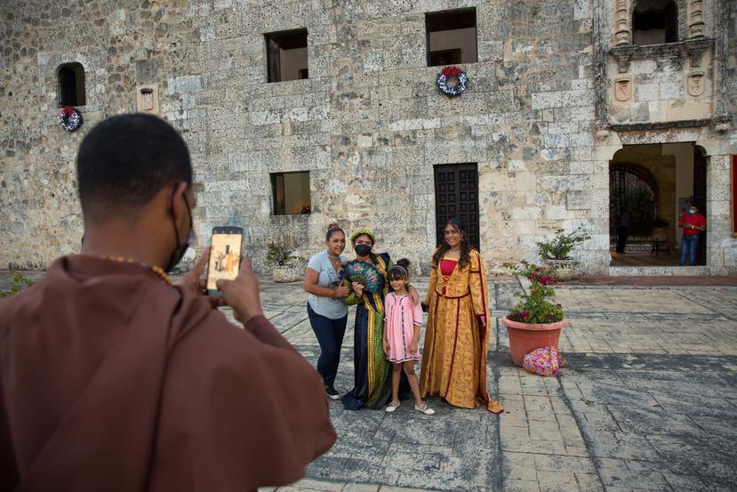 Una madre y su hija posan para una foto con dos mujeres vestidas de época que dan la bienvenida a los visitantes del museo de Las Casas Reales en Santo Domingo, República Dominicana.
