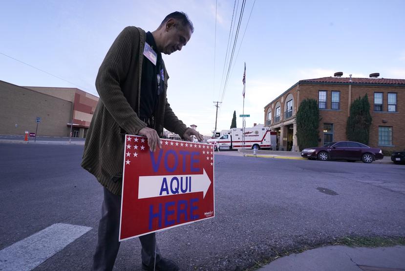 Un funcionario electoral ajusta un letrero que indica la entrada al centro de votación en El Paso, Texas.