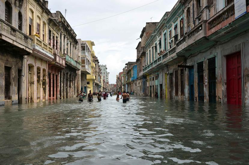 Personas caminan por una calle inundada tras el paso del huracán Irma, en La Habana, Cuba (Rolando Pujol / EFE).