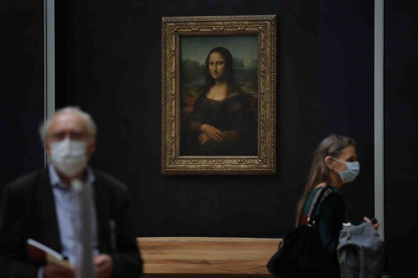 Periodistas pasan frente a la Mona Lisa de Leonardo da Vinci durante una visita al museo del Louvre previa a su reapertura el 6 de julio en París, el martes 23 de junio de 2020. (AP/Christophe Ena)