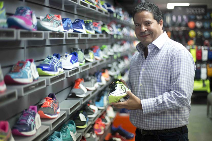 Eugenio Torres, gerente general de Deportes Salvador Colom, muestra la variedad de calzado deportivo con que cuenta la tienda en Puerto Nuevo.