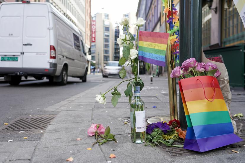 Flores acompañadas por los colores del orgullo LGBTQ+ yacen en el sitio donde un hombre armado se puso a disparar, el sábado 25 de junio de 2022, en el centro de Oslo.