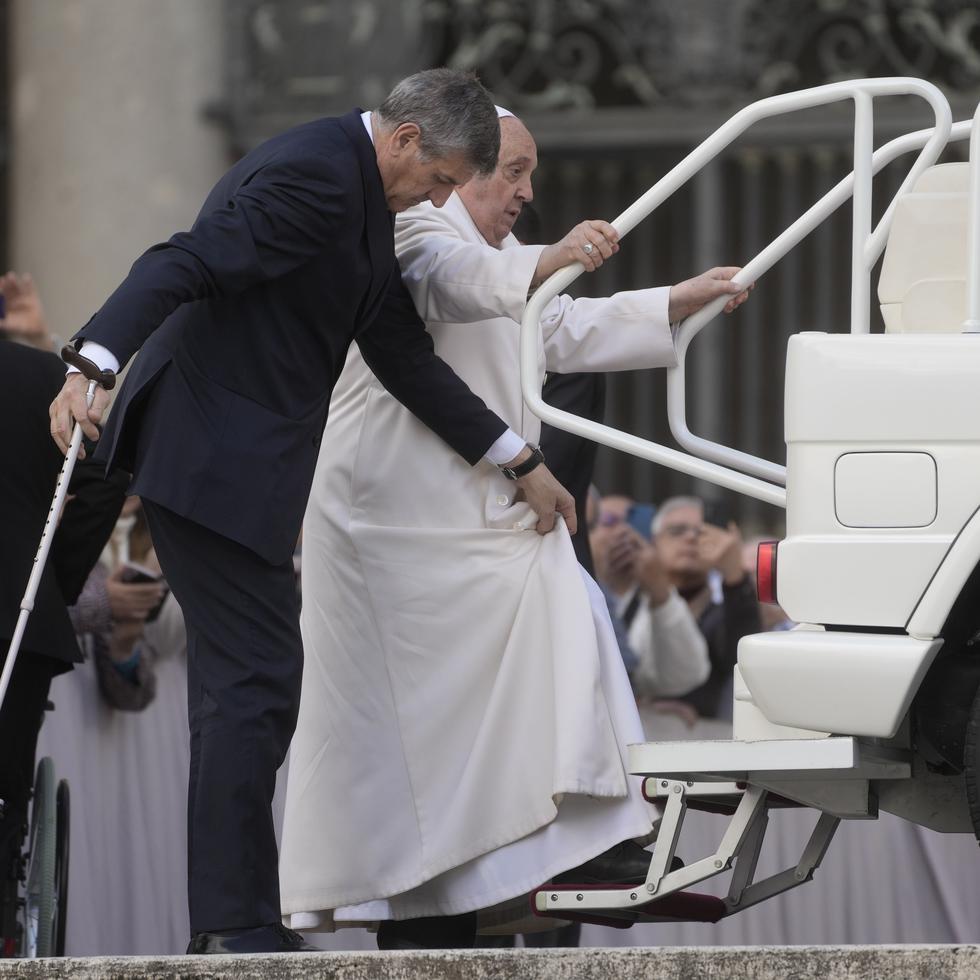 El papa Francisco trata de subirse al papamóvil en el Vaticano.