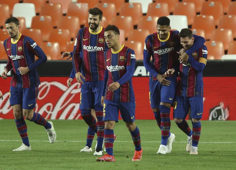 Lionel Messi (derecha) celebra con sus compañeros del Barcelona tras anotar el tercer gol en la victoria 3-2 ante el Valencia.