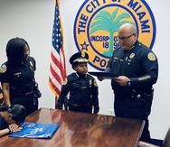 El niño Daniel DJ mientras posa con miembros del departamento de Policía de la ciudad de Miami.