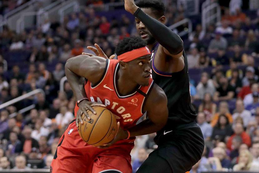 Pascal Siakam, alero de los Raptors de Toronto, controla el balón frente a Deandre Ayton, de los Suns de Phoenix, en el duelo del martes 3 de marzo de 2020 (AP Foto/Matt York)

