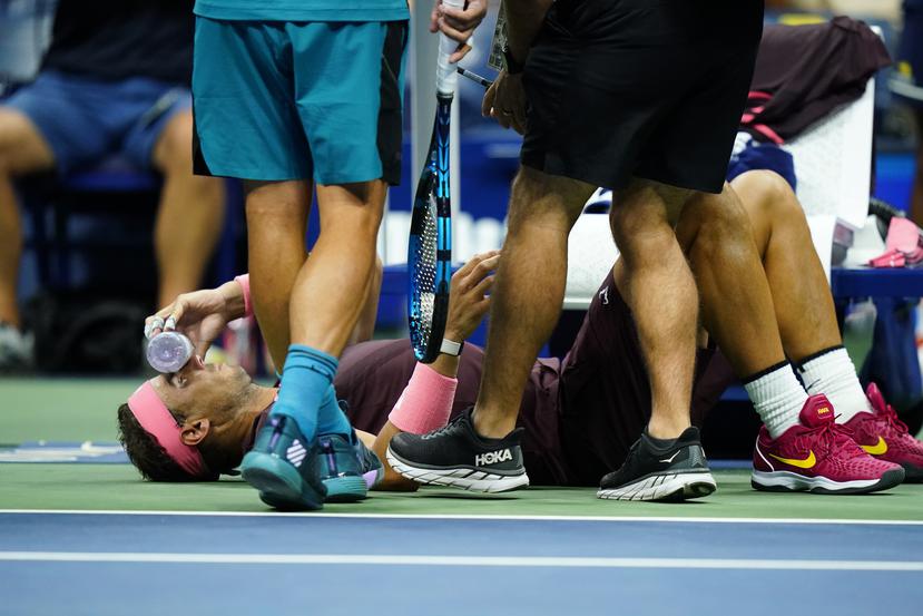 Rafael Nadal sostiene una botella en su rostro al recibir tratamiento durante el partido contra Fabio Fognini en la segunda ronda del US Open, el jueves 1 de septiembre de 2022.