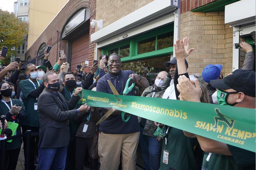 Shawn Kemp (centro) corta la cinta para inaugurar el dispensario de cannabis que lleva su nombre en la ciudad de Seattle.