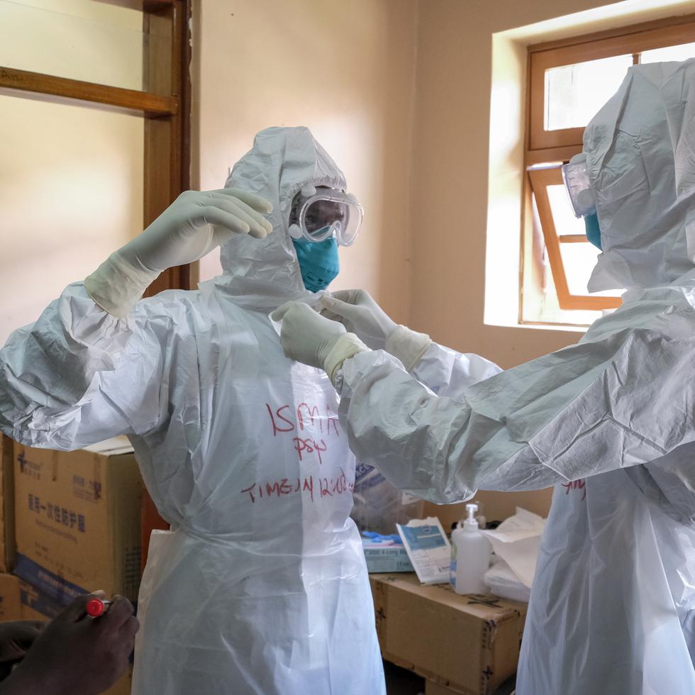 Imagen de archivo que muestra a médicos poniéndose equipos de protección para visitar a un paciente que estuvo en contacto con una víctima del ébola, en Uganda.