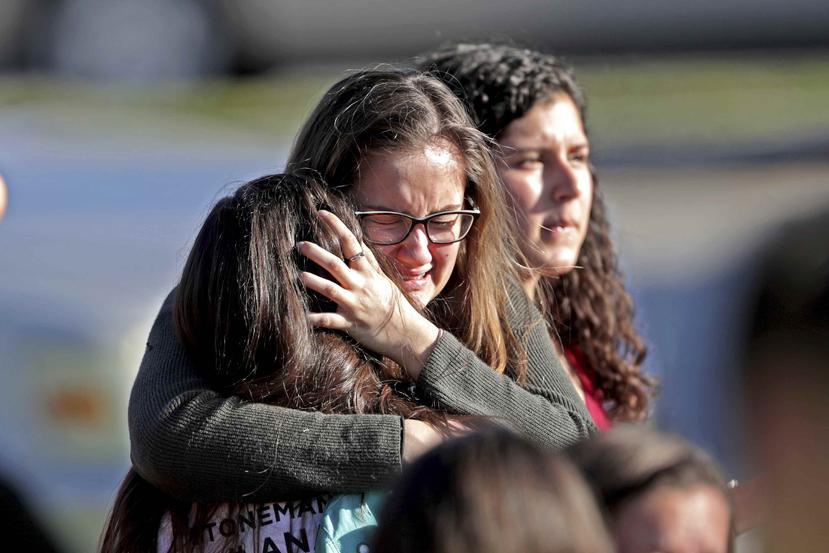 Una madre abraza a su hija fuera de la escuela donde ocurrió el tiroteo. (AP)
