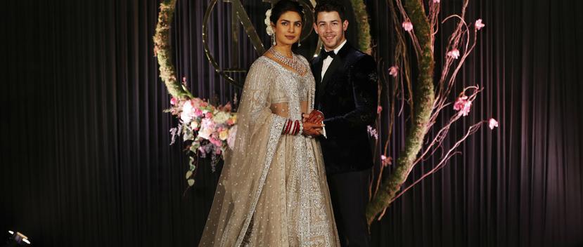 La actriz Priyanka Chopra y el cantante Nick Jonas posan para la prensa durante la recepción de su boda hindú. (Foto: AP)