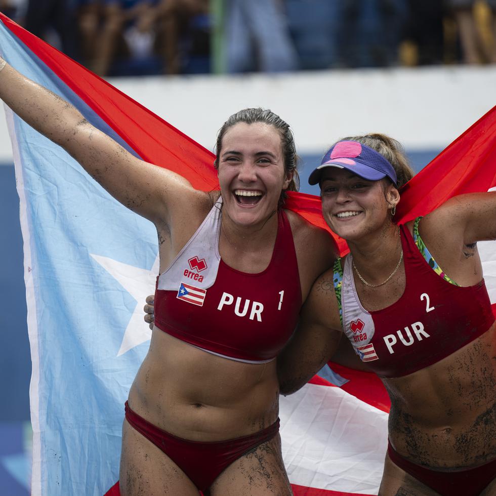 María González y Allanis Navas celebran con la bandera de Puerto Rico.