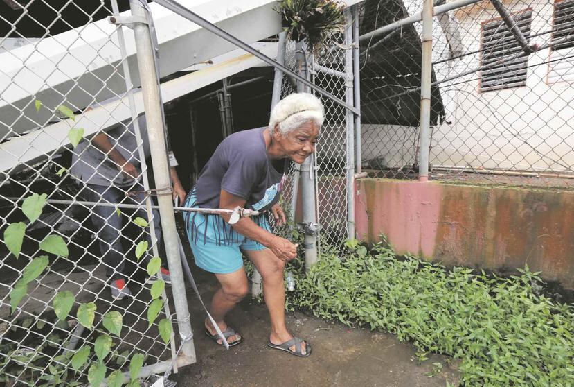 María Muñiz, residente de Villa Kennedy, recibió ayuda de un vecino para poder abrir un espacio en su balcón que le permitiera respirar.