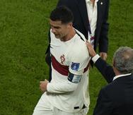 Fernando Santos, técnico de Portugal, le da una palmada en la espalda a Cristiano Ronaldo tras la eliminación en la Copa Mundial.