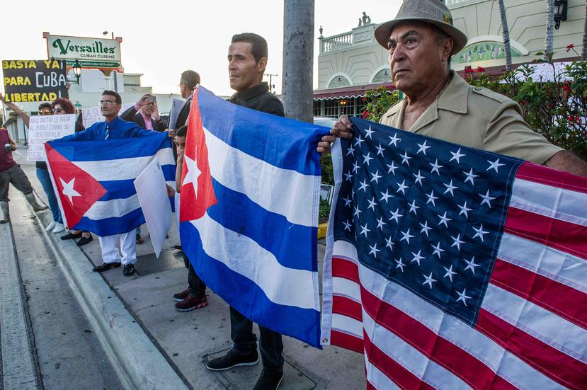Un grupo de personas levanta banderas cubanas y estadounidenses durante una vigilia convocada por varios de los más influyentes grupos del exilio cubano. (Agencia EFE)