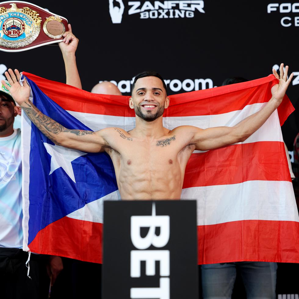 Un sonriente campeón Oscar Collazo levanta la bandera tras cumplir con el peso.