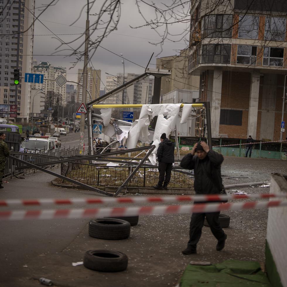 Policías inspeccionan una zona en Kiev, Ucrania, después de un aparente ataque ruso.