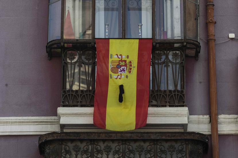 Una bandera española con una cinta negra en recordación a las víctimas del coronavirus cuelga desde un balcón en Madrid.