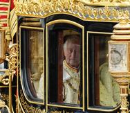 El rey Charles III de Gran Bretaña se ve a través de la ventana del carruaje estatal Diamond Jubilee cuando sale del Palacio de Buckingham con Camilla, la reina consorte, para la ceremonia de coronación en Londres, el sábado 6 de mayo de 2023.