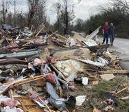 La gente camina a través de un área de estructuras destruidas en Flatwood, Alabama.
