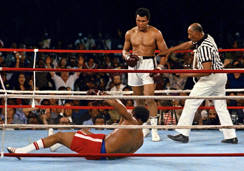 El árbitro Zack Clayton (derecha) interviene después de que Muhammad Ali derribara al campeón defensor de peso pesado George Foreman en el octavo asalto de su pelea por el campeonato el 30 de octubre de 1974, en Kinshasa, Zaire.