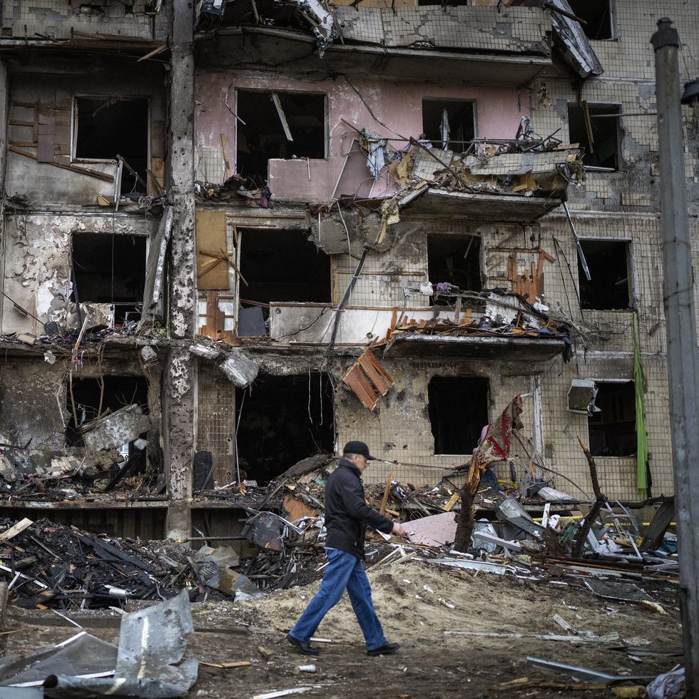 Un hombre camina en medio de los escombros luego de que un ataque con misil dañara un edificio en Kiev, la capital de Ucrania, el 25 de febrero de 2022. (AP Photo/Emilio Morenatti)