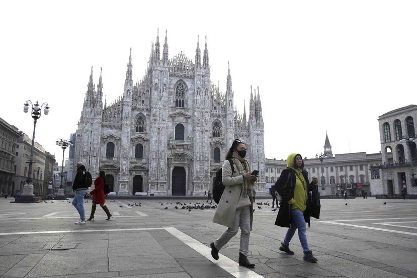 Una mujer con mascarilla pasa ante la catedral gótica del Duomo en Milán, Italia. (AP)