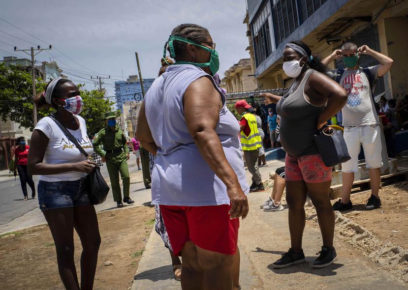 Varias personas ptotegidas con mascarillas en La Habana, Cuba. (AP)