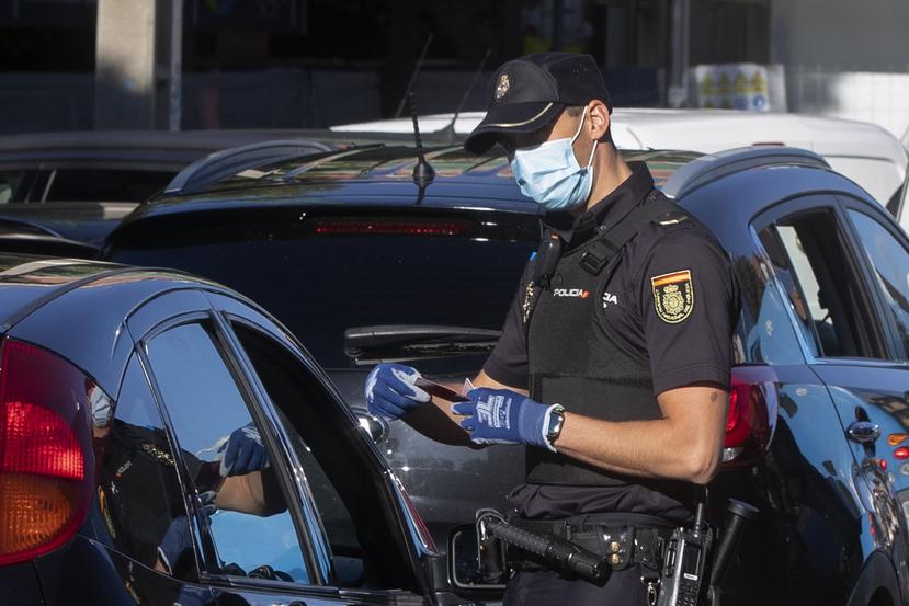 Un agente de policía comprueba la documentación de un conductor en un control a las afueras de Madrid, España, el 3 de octubre de 2020.