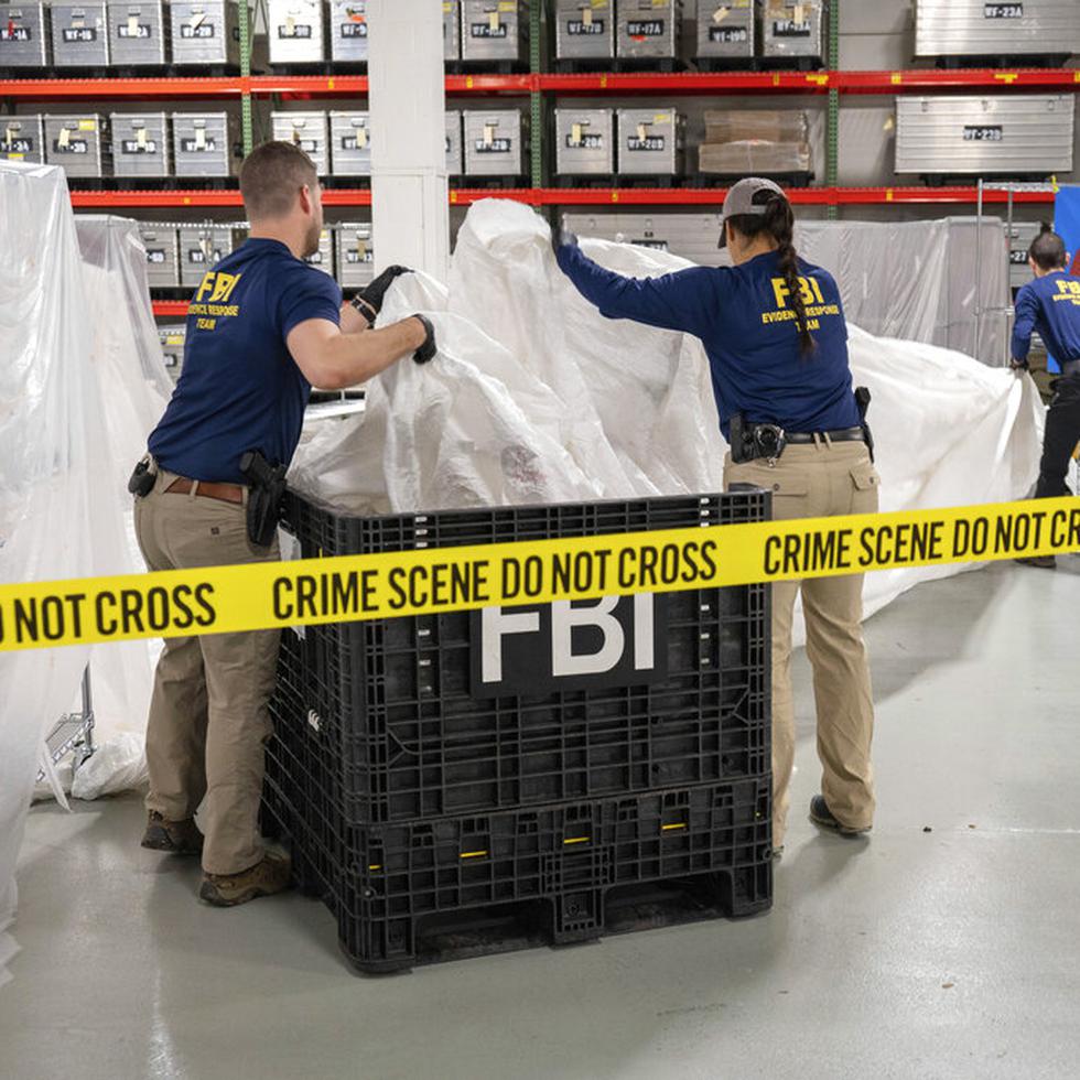 En esta imagen facilitada por el FBI, agentes asignados a un equipo especial manipulan el jueves 9 de febrero de 2023, en el laboratorio de la agencia, los materiales recuperados de un globo chino supuestamente espía que fue derribado en aguas frente a la costa de Carolina del Sur.